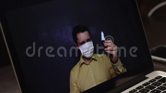 一位戴着医疗面具的视频博主正在笔记本电脑网络摄像头上录制广告视频他赞扬订阅者防止视频的预览图