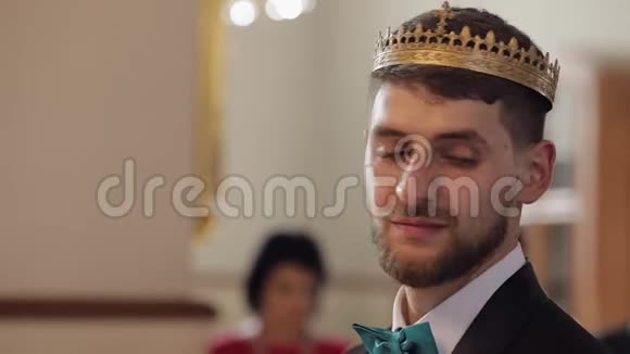 皇冠上的新郎站在教堂里他看着新娘微笑新婚夫妇视频的预览图