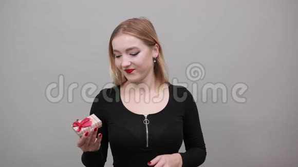 坐立不安的女人手里拿着礼品盒拇指向下视频的预览图