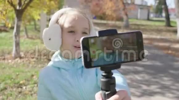 快乐可爱的小vlogger在公园长椅上制作在线视频录制vlog记录vlog和博客概念视频的预览图