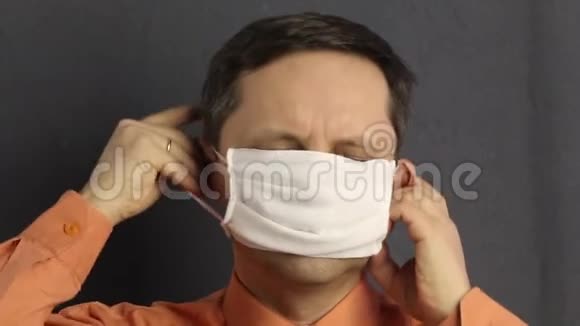 男人戴上纱布口罩它紧贴着她的耳朵把他的手伸直病毒防护视频的预览图