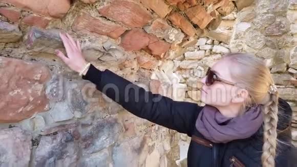 游客看着古堡里的一堵石墙视频的预览图