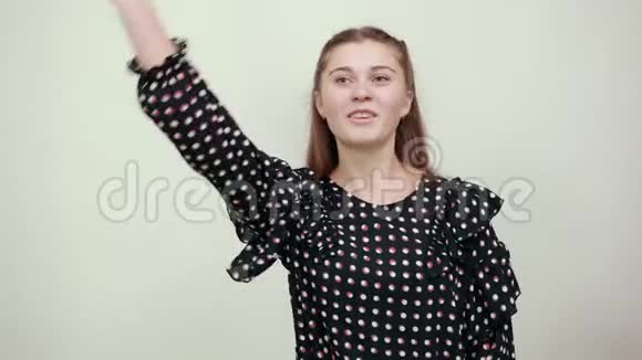 穿着白色圆圈的黑色裙子的女孩一边说话一边手牵手面对视频的预览图