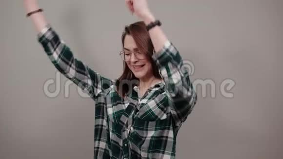 灰色背景戴眼镜跳舞的快乐女人视频的预览图