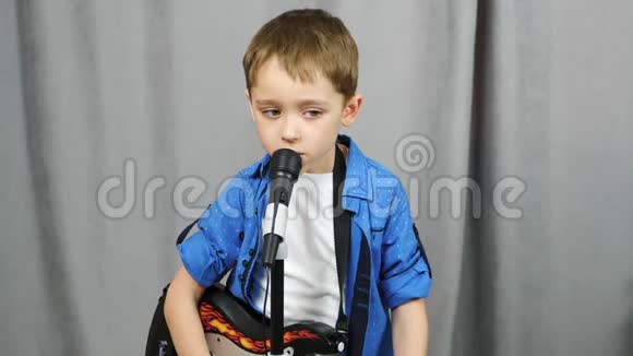 一个快乐的孩子花时间弹吉他一个小男孩用麦克风唱歌音乐发展生活方式视频的预览图
