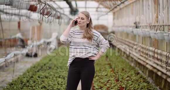 农业温室中使用手机的女园丁视频的预览图