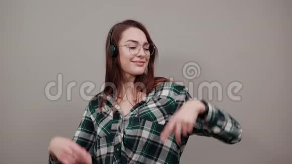 戴眼镜的快乐女人戴耳机听音乐手舞足蹈视频的预览图