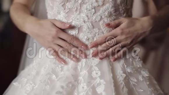 美丽可爱的新娘用手触摸她的婚纱慢动作视频的预览图