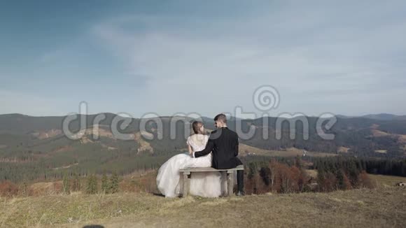 新婚夫妇白人新郎和新娘在山坡上新婚夫妇快乐视频的预览图