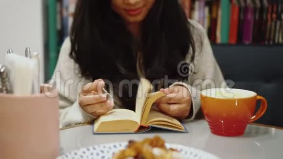漂亮女孩一边喝咖啡一边在咖啡馆看书咖啡屋的学习视频的预览图
