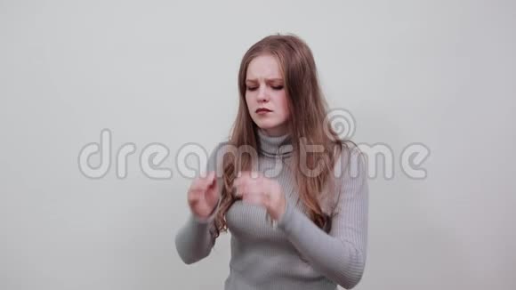 穿灰色毛衣的女人头疼手牵着头视频的预览图