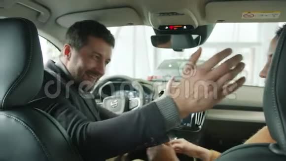 在经销商的漂亮新车里男人和女人拥抱的动作很慢视频的预览图