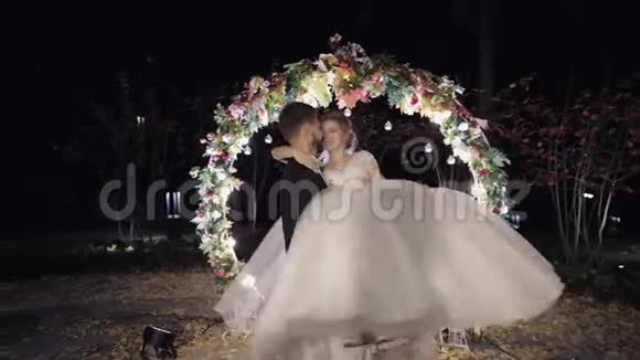 新婚夫妇白人新郎带着新娘靠近几英亩的鲜花夜间视频的预览图