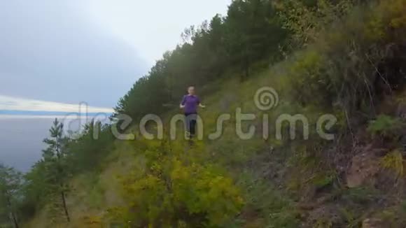 女孩沿着海岸陡峭斜坡的小径奔跑视频的预览图