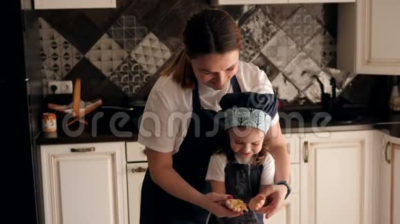 妈妈和小女儿在厨房里一起捏面团视频的预览图