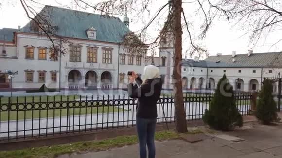 女游客在广场上拍了一张旧宫殿的照片视频的预览图