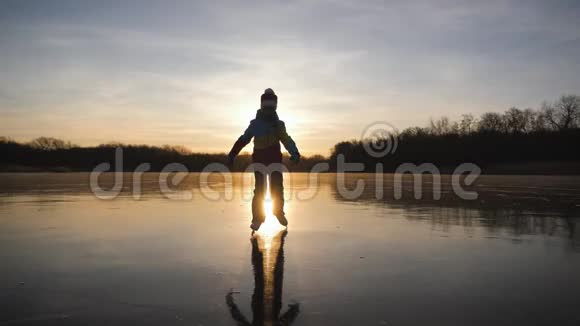 可爱的小女孩在日落时要去户外滑冰冬天一个在冰冻湖上滑冰的女生视频的预览图