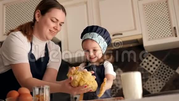 小女孩帮她妈妈准备纸杯蛋糕她把手掌弄脏了面团视频的预览图