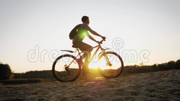 日落时骑自行车的山地自行车骑手的轮廓运动旅行和积极的生活理念视频的预览图