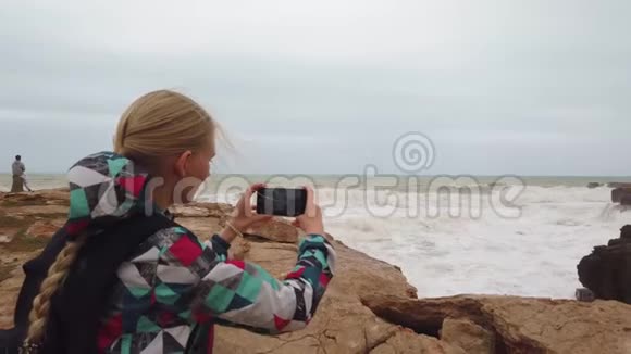 女孩站在她的背上在她的手机上拍了一张照片慢动作视频的预览图