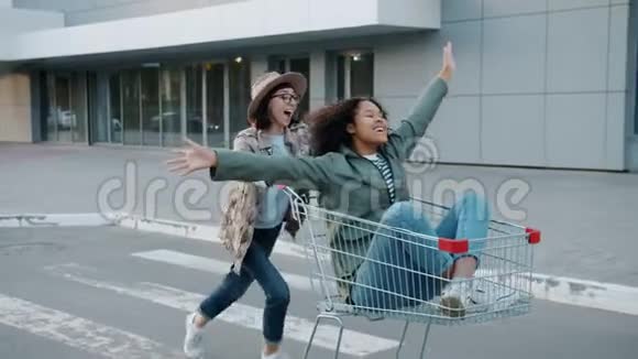 玩的年轻女士朋友们在街边的购物车外面玩得很开心视频的预览图