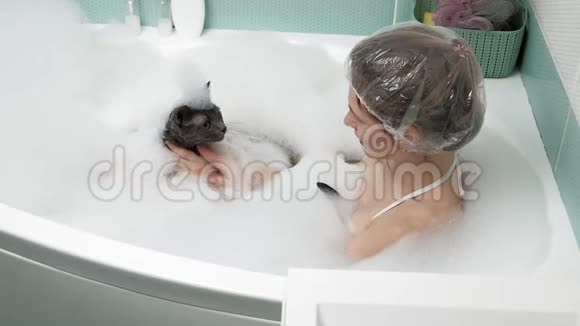 一个女人在浴室里给一只猫洗澡视频的预览图