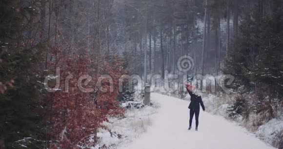 冬天在森林里摘围巾的女人视频的预览图