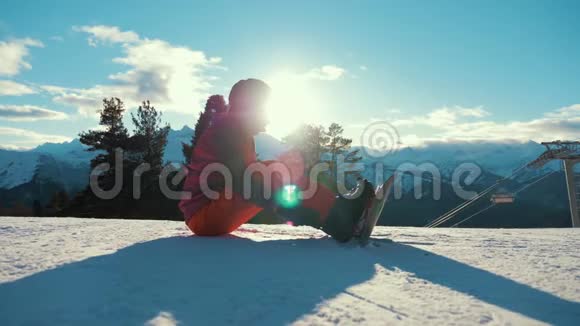 坐在山顶上享受山景的滑雪板女孩雪山上的运动女人美丽动人视频的预览图