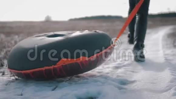 年轻女孩骑在一座小山上的充气雪管上视频的预览图