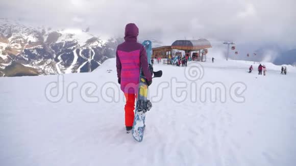 在滑雪场女孩滑雪者手里拿着滑雪板雪山上的运动女人滑雪冬季阳光明媚视频的预览图