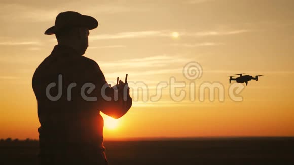 日落时分一个农民在麦田里使用无人机的剪影增加概念技术创新视频的预览图