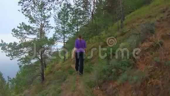 沿着贝加尔湖海岸陡峭的斜坡沿着女孩的射击而下视频的预览图