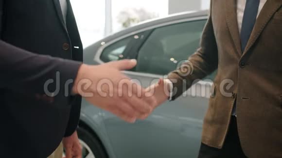 慢动作特写男士握手在汽车陈列室拿钥匙fo视频的预览图