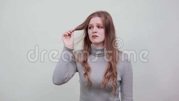 头发灰白的红发女人绝望地看着脆弱的头发后悔沮丧视频的预览图