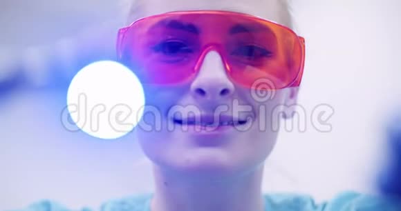 牙科医生在医疗诊所手术期间使用紫外线固化剂视频的预览图