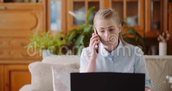 家庭办公概念女人在手机上交谈和使用笔记本电脑视频的预览图