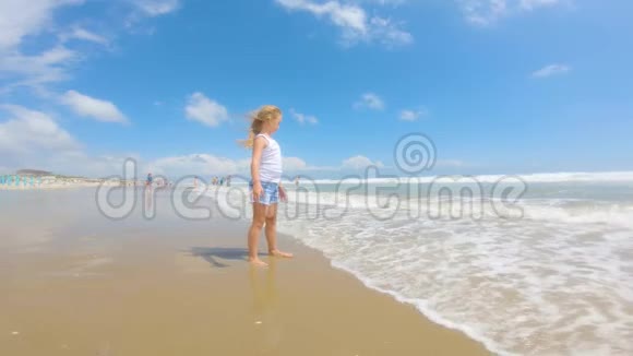 女孩看着大海头发里有风美丽的金发在风中发展她很快乐海边的孩子视频的预览图