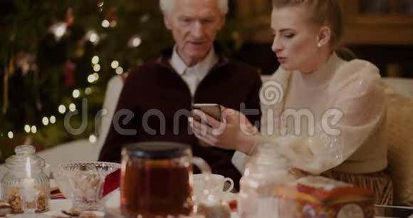 在圣诞节教祖父使用智能手机的女人视频的预览图