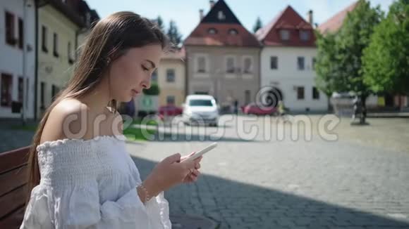 女孩用互联网和智能手机进行户外休闲视频的预览图