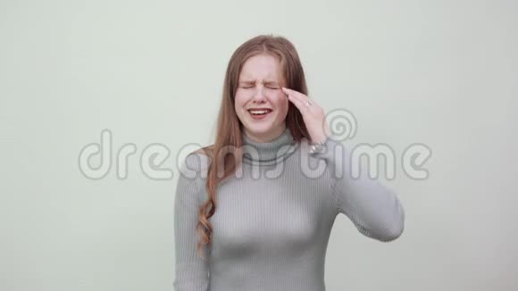 一位身穿灰色毛衣的红发美女扭着手指绕着头视频的预览图