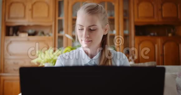 微笑的女人在家庭办公室的笔记本电脑上工作女商人在电脑键盘上打字视频的预览图