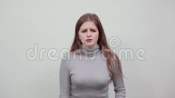 背景上穿灰色毛衣的漂亮女人胃疼视频的预览图