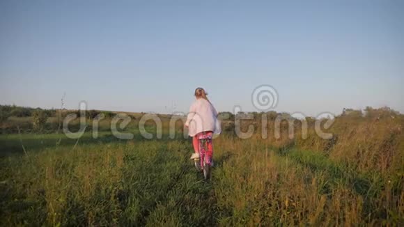 少女骑着自行车在乡村夕阳的时候生活方式的概念视频的预览图