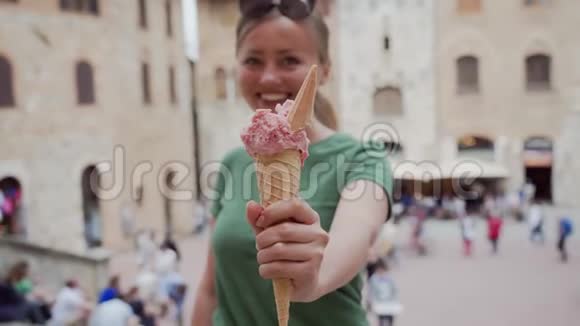 快乐的黑发女孩戴着眼镜手里拿着粉红色的雪糕筒和意大利冰淇淋视频的预览图