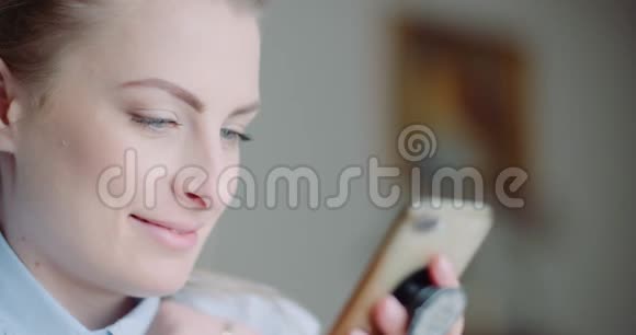 美丽的女人使用智能手机和微笑视频的预览图