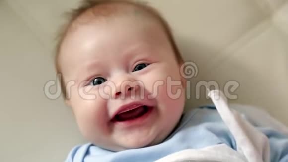 新生婴儿躺在镜头前微笑微笑的小女孩躺在床上视频的预览图