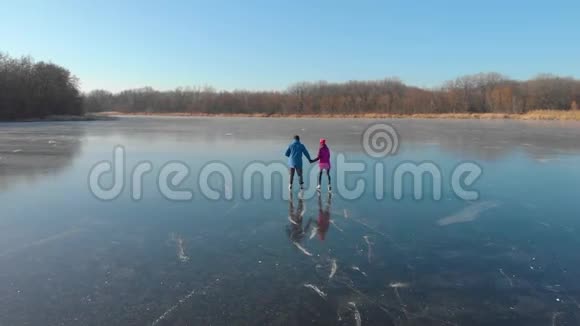 一对快乐的夫妇在一个可爱的阳光明媚的冬日在冰冻的湖面上户外滑冰滑冰可爱的情侣冬天来了视频的预览图