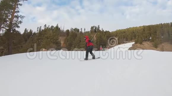滑雪板上的滑雪者沿着滑雪胜地的斜坡奔跑冬季运动娱乐休闲户外活动视频的预览图