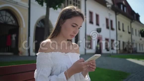 城市里的女游客用智能手机休息视频的预览图