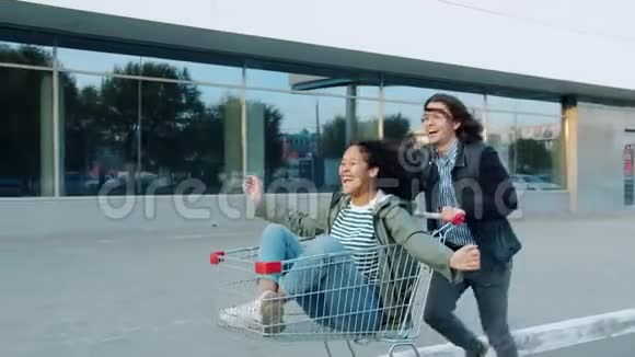 玩的青年男女玩得开心骑着购物车笑视频的预览图